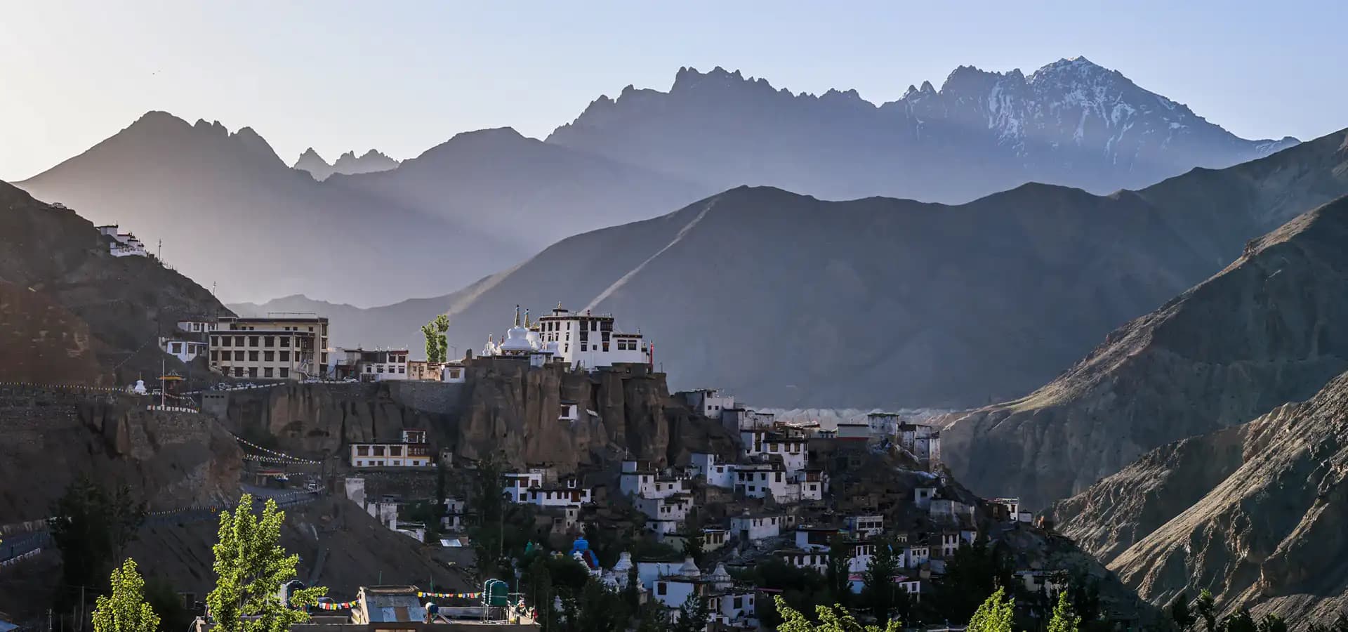 Voyage à moto au Ladakh dans l’Himalaya Monastère et village du Ladakh entourés de hauts sommets lors d’un voyage à moto en Inde